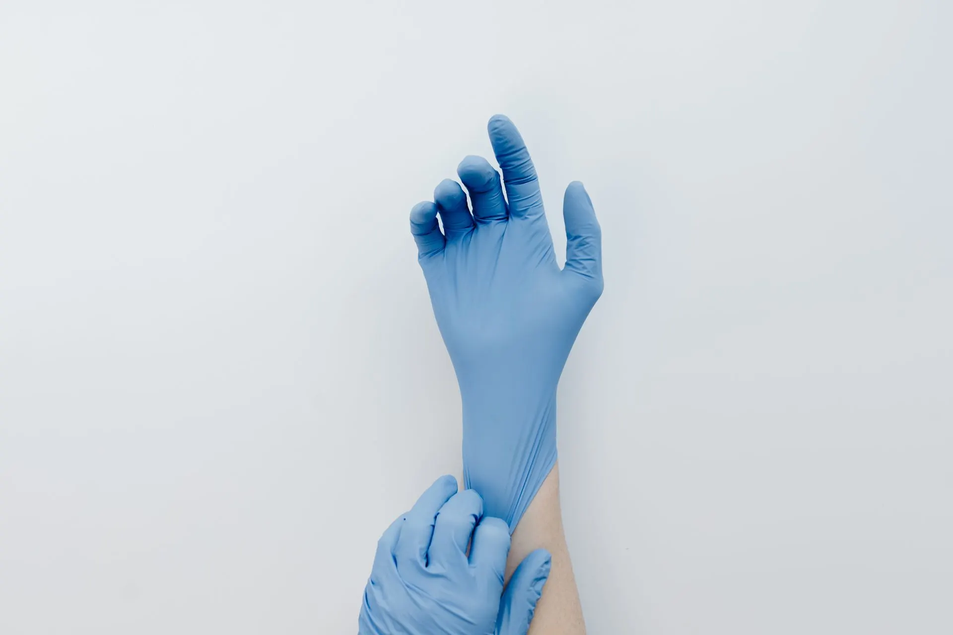 Hands putting on disposable gloves