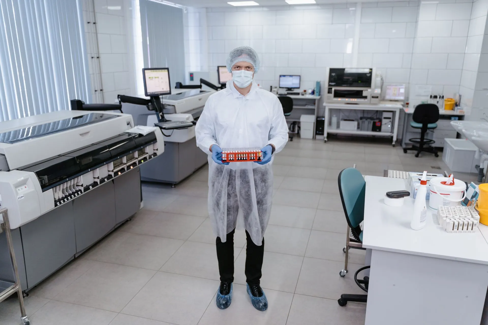 Laboratory staff in disposable gown, cap and shoe covers